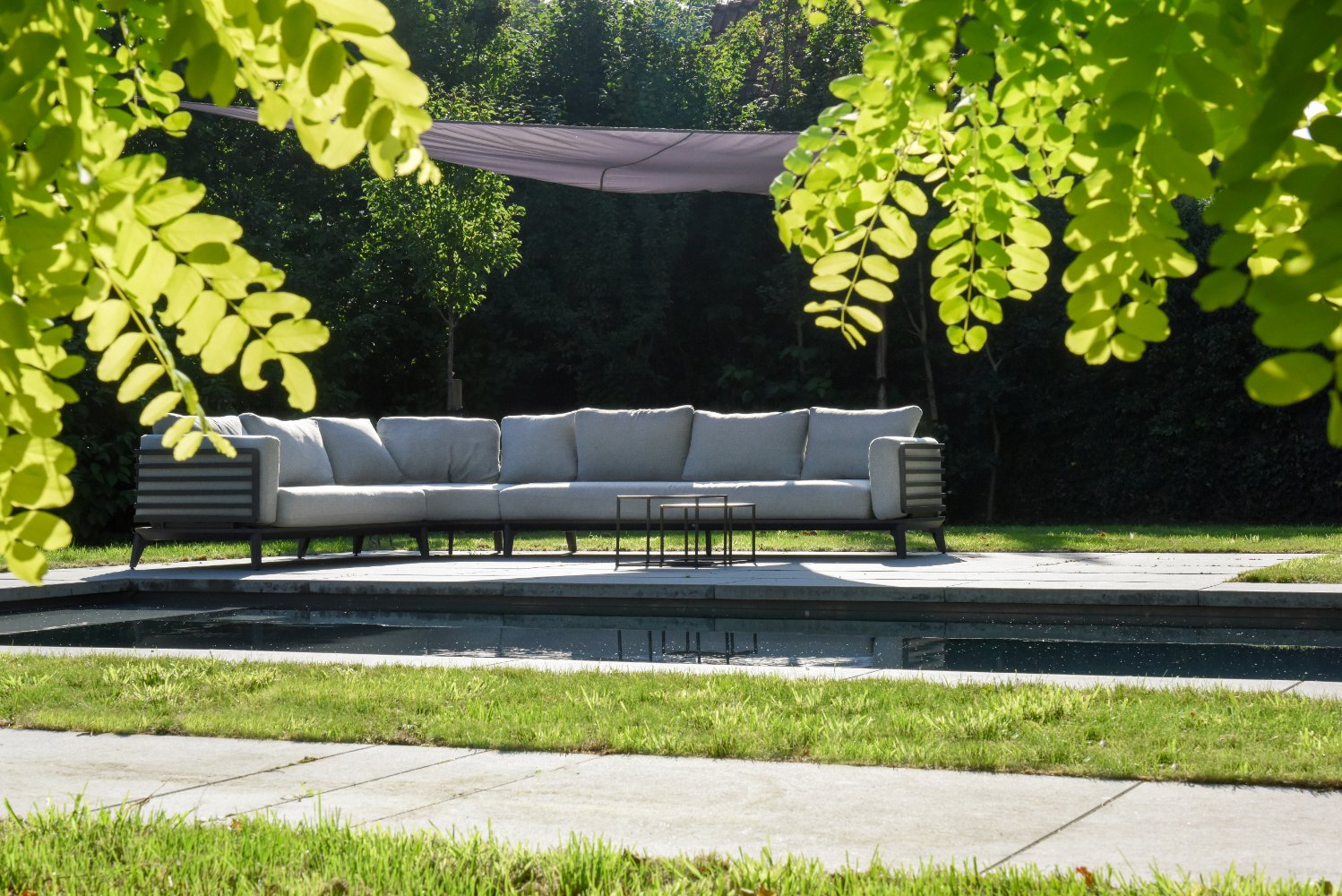loungezetel op het terras naast een bio zwembad of biopool in een parktuin 